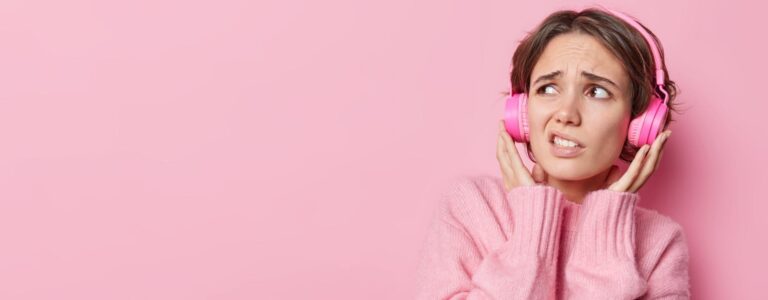 Mulher usando fones ouvido e fazendo careta.