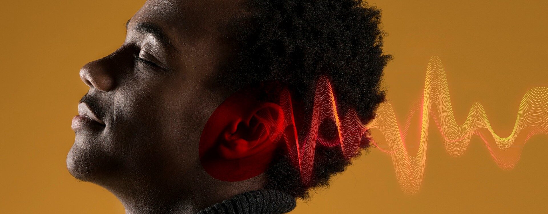 Homem de perfil ouvindo música de olhos fechados.