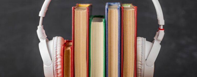 Fone de ouvido colocado em volta de alguns livros.