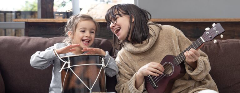 Mãe e filha tocando instrumentos musicais juntas.