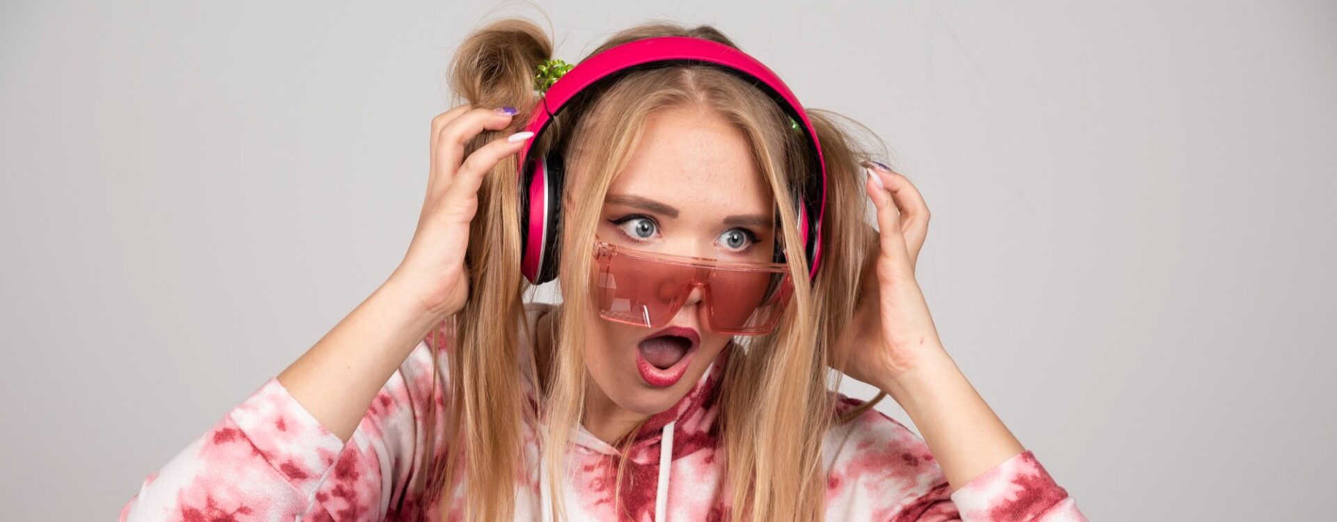 Mulher usando fones de ouvido com cara de assustada.