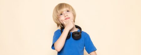 Criança usando fones de ouvido em volta do pescoço.
